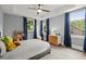 A comfy bedroom with a grey bed frame, carpeted floors, and two large windows at 3668 Spring St, Chamblee, GA 30341