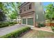 Side view of brick and green-paneled house with a two-car garage, brick accents and landscaped bushes at 3668 Spring St, Chamblee, GA 30341