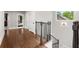 Upstairs hallway features hardwood floors, neutral paint, and iron railing at 3668 Spring St, Chamblee, GA 30341