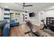 A recreation room with home gym equipment, hardwood floors, a blue sectional sofa, and patio access at 3668 Spring St, Chamblee, GA 30341
