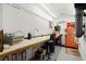 A workshop with pegboard, fluorescent lighting, a workbench, and storage for tools and equipment at 3668 Spring St, Chamblee, GA 30341