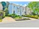 A view of the townhome's exterior shows lush landscaping and a driveway leading to the garage at 3688 E Bay St, Duluth, GA 30096