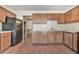 Kitchen with wooden cabinets, black appliances, and laminate flooring at 3688 E Bay St, Duluth, GA 30096