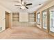 Living room with carpeting, built in cabinets, shelves, and double doors to back patio at 3688 E Bay St, Duluth, GA 30096