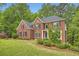 Beautiful two-story brick home featuring a well-manicured lawn and lush landscaping at 3801 Bays Ferry Trl, Marietta, GA 30062
