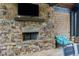 Outdoor stone fireplace with mounted television and comfortable seating at 569 Mirrormont Se Dr, Smyrna, GA 30080