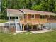 Backyard featuring a wooden deck, stairs, a brick house, and plenty of green grass and trees at 3471 Elgin Dr, Decatur, GA 30032