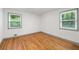 Bright bedroom with hardwood floors and white walls showcasing natural light from the two windows at 3471 Elgin Dr, Decatur, GA 30032
