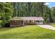 Charming brick home with a well-manicured lawn and a covered porch, surrounded by lush trees at 3471 Elgin Dr, Decatur, GA 30032