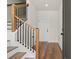 Foyer with hardwood floors, staircase with wooden railing, and a white interior door at 1122 W Marietta St, Atlanta, GA 30318
