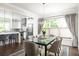 Elegant dining room with a glass-top table, modern chandelier, and a view into the kitchen at 1378 Lochland Se Rd, Atlanta, GA 30316