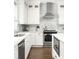 Modern kitchen featuring white cabinets, stainless steel appliances, and a sleek range hood at 1378 Lochland Se Rd, Atlanta, GA 30316