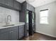 Contemporary laundry room with gray cabinetry, stylish sink, and stacked washer/dryer at 1378 Lochland Se Rd, Atlanta, GA 30316