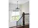 Bright stairwell boasting a modern chandelier and a large window with backyard views at 1378 Lochland Se Rd, Atlanta, GA 30316
