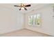 Bedroom with neutral carpet, ceiling fan, tray ceiling and plantation shutters allowing for natural light at 2017 Harts Mill Ne Rd, Chamblee, GA 30341