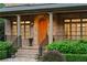 Attractive front entry with an arched wooden door, brick accents, and manicured shrubs at 2017 Harts Mill Ne Rd, Chamblee, GA 30341