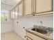 Bright laundry room featuring ample cabinetry, granite counters, and a stainless steel sink at 2017 Harts Mill Ne Rd, Chamblee, GA 30341