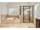 Elegant bathroom featuring a soaking tub, glass shower, and travertine surround at 2017 Harts Mill Ne Rd, Chamblee, GA 30341