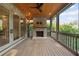 Screened-in porch with a brick fireplace, wood-paneled ceiling with fan, and views of the surrounding greenery at 2017 Harts Mill Ne Rd, Chamblee, GA 30341