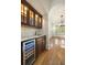 Wet bar with custom dark wood cabinets, granite countertop, tile backsplash, and wine cooler at 2017 Harts Mill Ne Rd, Chamblee, GA 30341