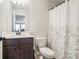 Cozy bathroom featuring a vanity, toilet, and a shower with floral curtain at 35 Henson Farm Dr, Loganville, GA 30052