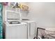 Bright laundry room with white washer and dryer, and organized shelving at 35 Henson Farm Dr, Loganville, GA 30052