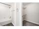 Bathroom with a shower-tub combo and a view into a carpeted closet with wire shelving at 3765 Windsor Cir, Clarkston, GA 30021