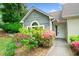 Inviting exterior with lush pink bushes by the front door and arched window, and a well maintained lawn at 3765 Windsor Cir, Clarkston, GA 30021