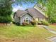 Charming home exterior with lush landscaping, flowering bushes, and steps to the entrance at 3765 Windsor Cir, Clarkston, GA 30021