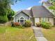 Charming home featuring light green siding, an arched window, and a well-maintained front yard with vibrant flower bushes at 3765 Windsor Cir, Clarkston, GA 30021