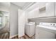Convenient laundry room with white cabinets above a newer washer and dryer unit at 3765 Windsor Cir, Clarkston, GA 30021