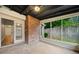 Enclosed sunroom with a brick accent wall offering an inviting space for relaxation or entertaining at 3765 Windsor Cir, Clarkston, GA 30021