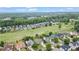Real estate aerial view of neighborhood homes overlooking verdant golf course and lush woodlands at 5375 Glenhaven Dr, Cumming, GA 30041