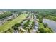 Real estate aerial view of a lovely, tree-lined residential area adjacent to a verdant golf course at 5375 Glenhaven Dr, Cumming, GA 30041