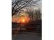 Sunset view of a backyard with a wooden fence and bare trees, creating a serene atmosphere at 5375 Glenhaven Dr, Cumming, GA 30041