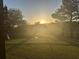 Backyard with lush green grass and beautiful sunlight shining over the wooden fence at 5375 Glenhaven Dr, Cumming, GA 30041