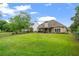 Large, well-kept backyard with a covered patio, green grass, and a classic wood fence at 5375 Glenhaven Dr, Cumming, GA 30041