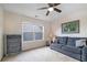 Relaxing bedroom with neutral walls, ceiling fan, a gray sofa, and a large window at 5375 Glenhaven Dr, Cumming, GA 30041