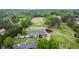Aerial view of golf course, clubhouse, and surrounding lush trees and landscaping at 5375 Glenhaven Dr, Cumming, GA 30041