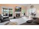 Cozy living room with a stone fireplace, large windows, comfortable seating, and a view to a covered back porch at 5375 Glenhaven Dr, Cumming, GA 30041