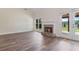 Sunlit living room features a fireplace, hardwood flooring, large windows, and access to the outdoor patio at 5375 Glenhaven Dr, Cumming, GA 30041