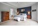 Main bedroom with a large bed, a dresser, and a view of the ensuite bathroom at 5375 Glenhaven Dr, Cumming, GA 30041