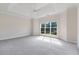 This main bedroom features carpet, a tray ceiling, a ceiling fan, and a window with a view at 5375 Glenhaven Dr, Cumming, GA 30041