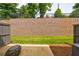 View of a backyard with a retaining wall, privacy fence, green lawn, and small patio at 1624 Gunnin Nw Trce, Atlanta, GA 30318