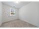 Neutral bedroom featuring a bright window, soft carpet, and minimalist flower decals on the white walls at 1624 Gunnin Nw Trce, Atlanta, GA 30318