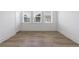 Bright bedroom featuring wood-look flooring, three windows, and a crisp white trim at 1624 Gunnin Nw Trce, Atlanta, GA 30318