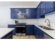 Close up of stunning kitchen featuring blue cabinets, herringbone backsplash, and stainless steel appliances at 1624 Gunnin Nw Trce, Atlanta, GA 30318