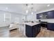 Open kitchen with a central island, stainless steel appliances, and a living room with a white couch at 1624 Gunnin Nw Trce, Atlanta, GA 30318