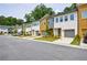 Charming street view of the multi-colored townhomes with attached garages, driveways, and professionally landscaped yards at 1624 Gunnin Nw Trce, Atlanta, GA 30318