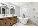 Modern bathroom featuring double vanities, a freestanding tub and elegant marble tile accents at 3019 Camden Way, Alpharetta, GA 30005